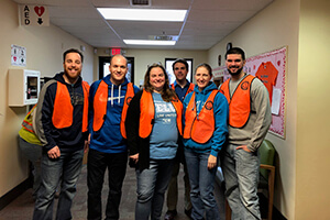 Emerging Leaders United members in orange vests for volunteer opportunity at food bank