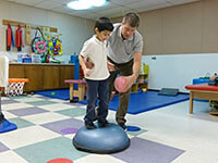 Young boy receiving physical therapy from staff member at Easterseals