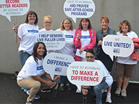 Alcon volunteers at United Way of Berks County kickoff event with Tammy White and holding signs