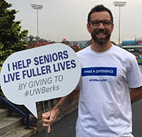 Volunteer holding sign saying I help seniors live fuller lives at United Way of Berks County Kickoff event