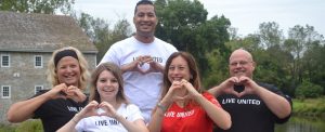 group of loaned campaign specialist wearing live united shirts making hearts with their hands