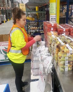 Volunteer working at Food Bank wearing orange safety vest