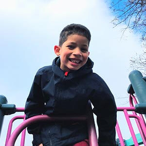 young boy on playground smiling at camera