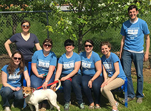 Emerging Leaders United at Humane Society in a group with a dog
