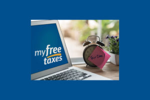 File Your Simple Tax Return for Free - image of laptop and clock on a desk