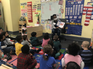 A woman is reading to a classroom of children