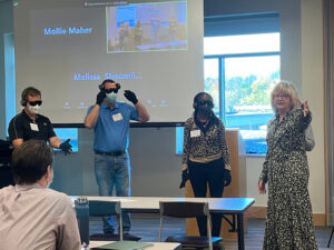 A group of adults are participating in an elder simulation. They're wearing special goggles and glvoes