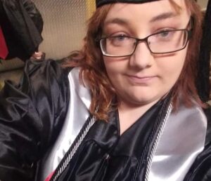 a woman wearing a cap and gown is taking a selfie