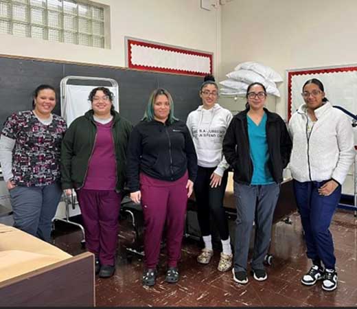 A group of women are standing side-by-side at their CNA graduation