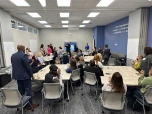 A wide shot of people sitting in a training room having breakfast