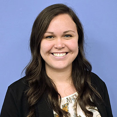 Head shot of a woman standing against a blue background