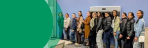A group of women are lined up in a conference room, smiling for the camera