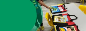 A boy is pointing at books on a table