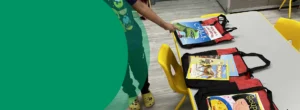 A boy is pointing at books on a table