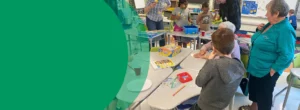 A group of adults and kids are playing games in a school library